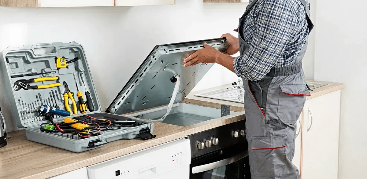 Handyman repairing a cooktop and checking wiring connections in Sterling Heights, MI