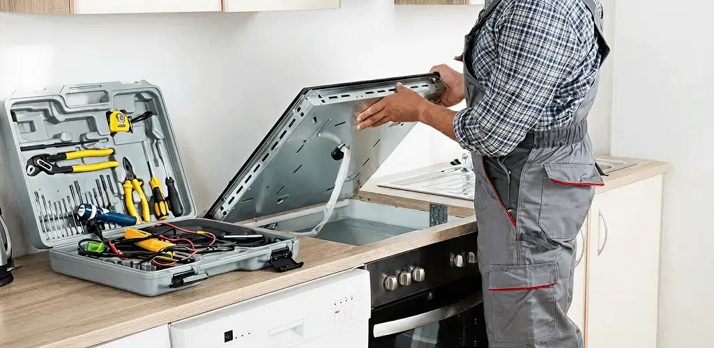Handyman repairing a cooktop and checking wiring connections in Sterling Heights, MI