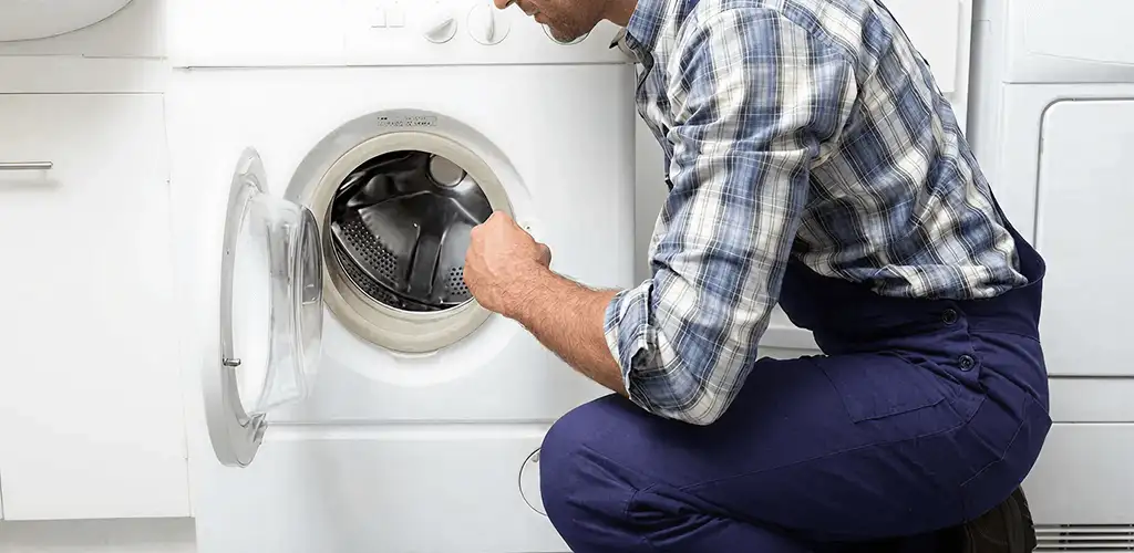 Handyman inspecting a dryer drum and internal parts for repair in Sterling Heights, MI