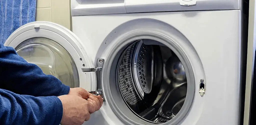 Washing machine repair handyman checking a front-load washer door and latch in Sterling Heights, MI