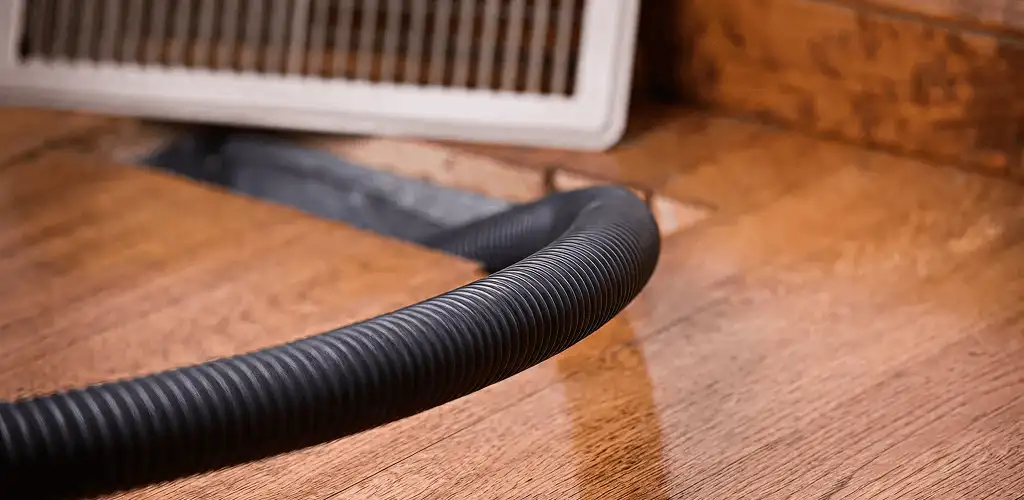 Air duct cleaning hose inserted into a floor vent for ductwork cleaning in Sterling Heights, MI