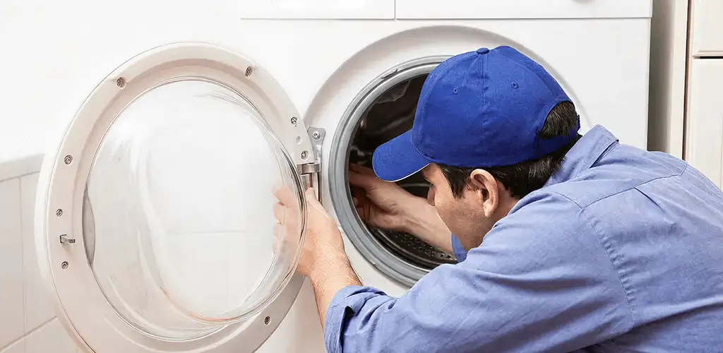 Washing machine repair handyman inspecting a front-load washer drum in Sterling Heights, MI