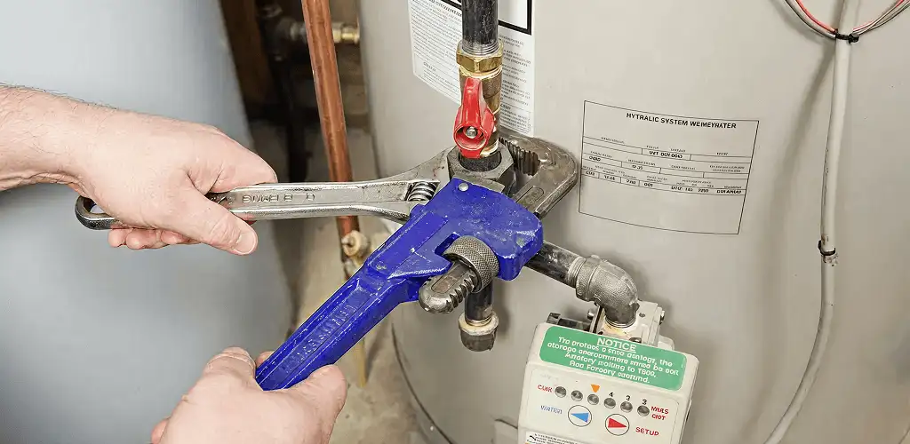 Water heater repair technician tightening the shutoff valve and supply line in Sterling Heights, MI